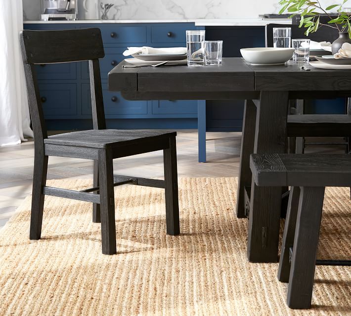 a dining room table with two chairs and a bowl on the table next to it