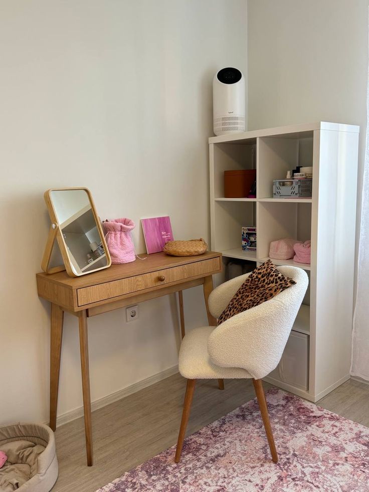 a white chair sitting in front of a desk with a mirror on top of it