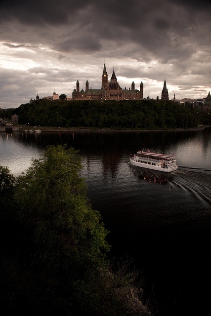 a boat traveling on the water in front of a castle