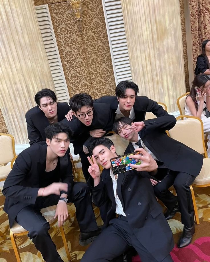 a group of young men posing for a photo in front of a room full of chairs