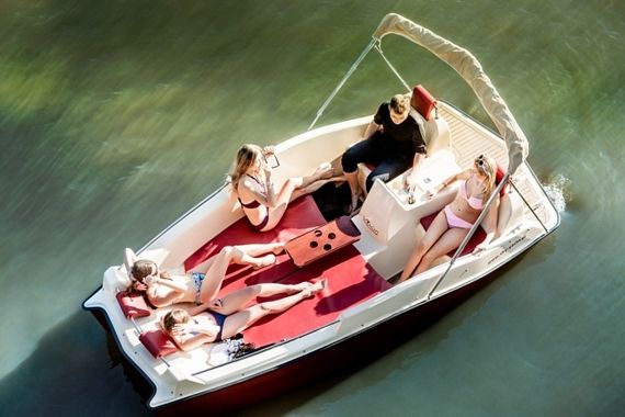 four women sitting on the back of a small boat