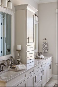 a white bathroom with two sinks and mirrors