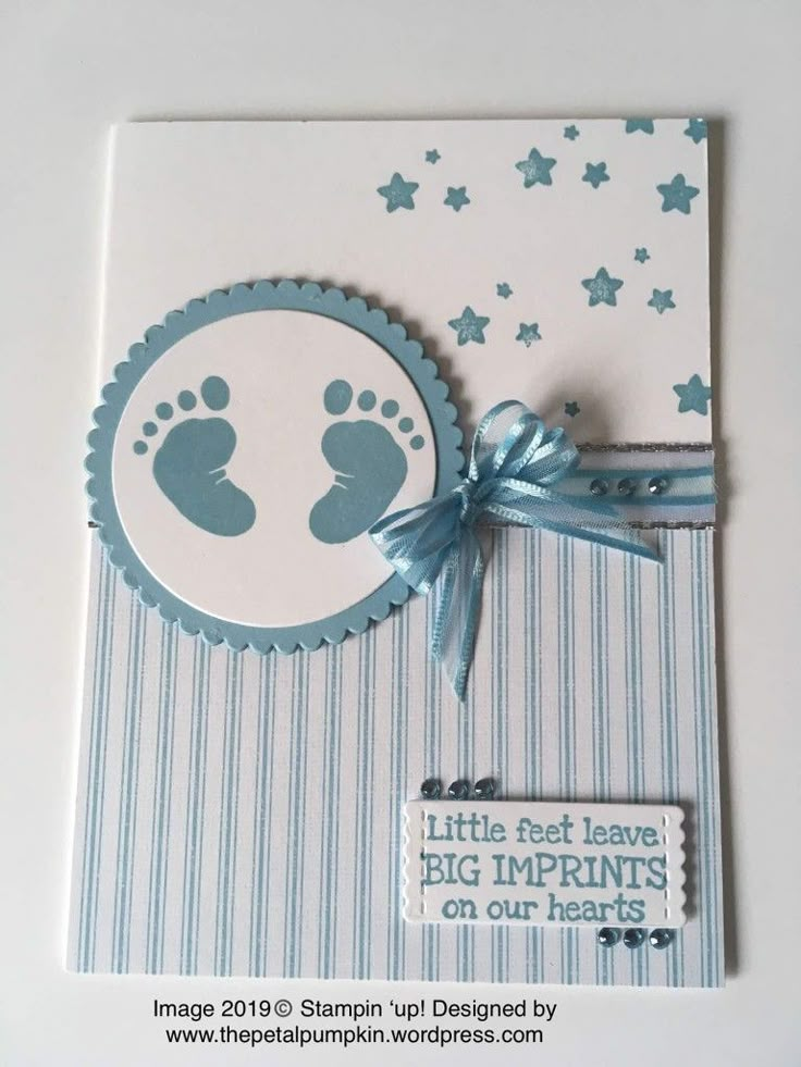 a card with a baby footprints on it and a blue ribbon tied around the edge