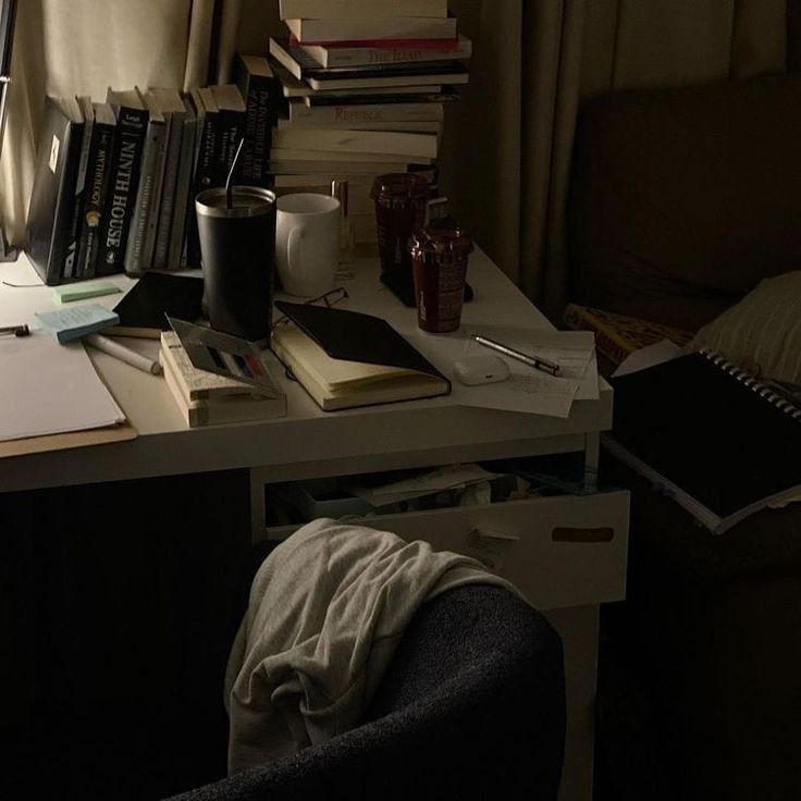 a messy desk with books and papers on it