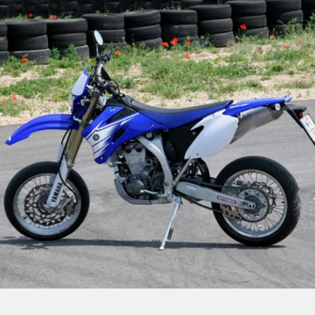 a blue and white dirt bike parked on the street