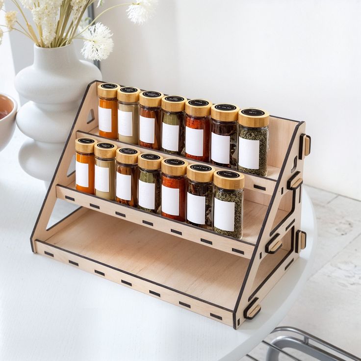 a wooden spice rack with six jars on it next to a white vase filled with flowers