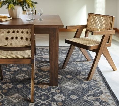 a dining table with two chairs next to it and a potted plant on top