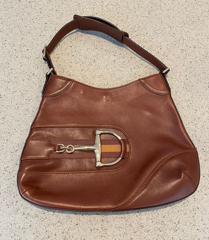 This classic Gucci Web Horsebit Hobo purse is brown leather with a great horsebit feature on the front. The leather strap measures 16 inches. The purse measures 13 1/2 x 10 1/2 inches. The interior of the purse is in pristine condition. There are a few small marks on the front of the purse- see photos. No dust bag, cards or receipt available. Please go to my shop- Carter Jewelry22- for more fabulous vintage and antique pieces! Also follow me on Instagram at CarterJewelry. Travel Satchel Shoulder Bag With Horsebit Detail, Office Shoulder Bag With Horsebit Detail, Travel Shoulder Bag With Horsebit Detail Satchel, Everyday Satchel Shoulder Bag With Horsebit Detail, Luxury Brown Shoulder Bag With Horsebit Detail, Designer Satchel Shoulder Bag With Horsebit Detail, Designer Shoulder Bag With Horsebit Detail For Business, Brown Saddle Shoulder Bag With Gold-tone Hardware, Brown Rectangular Shoulder Bag With Horsebit Detail