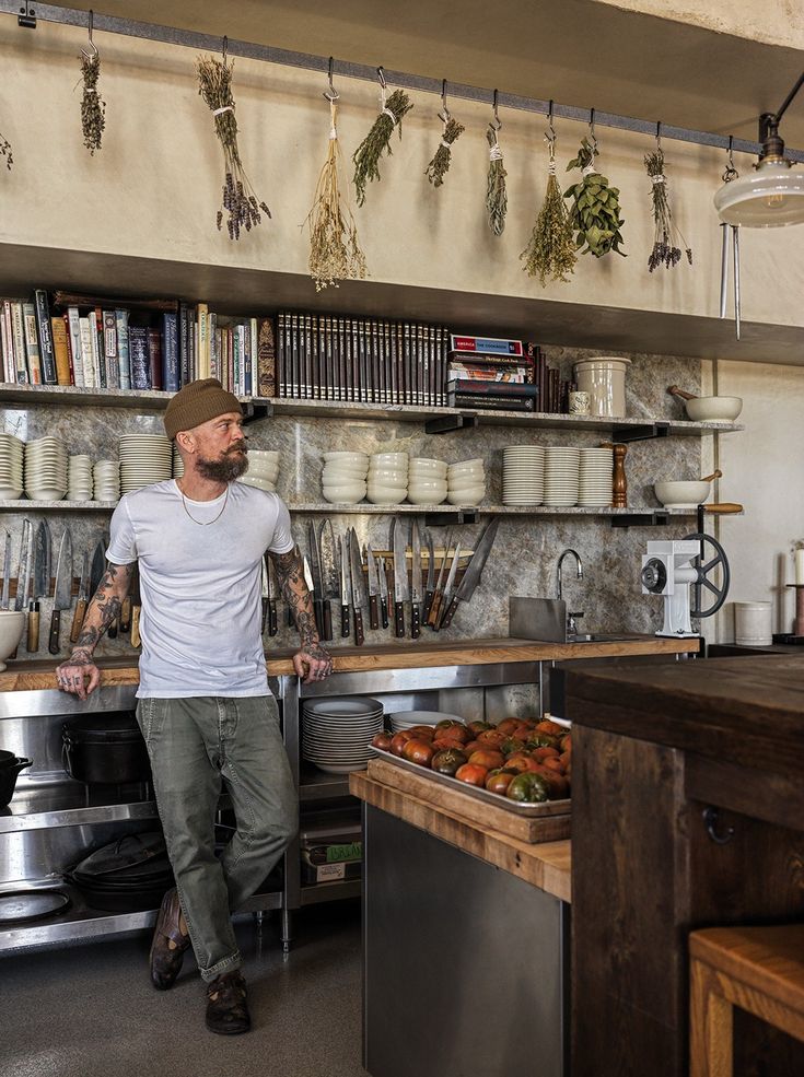 a man standing in front of a counter filled with lots of food and drinks on shelves