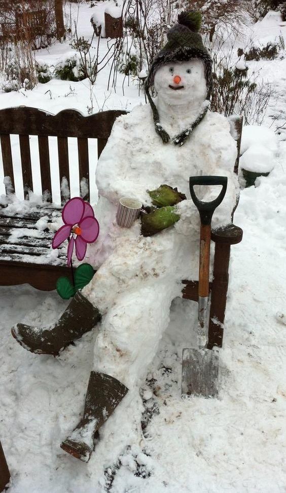 a snowman sitting on top of a bench next to a flower pot and shovel