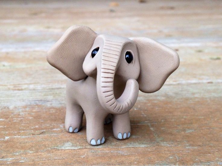 an elephant figurine sitting on top of a wooden floor