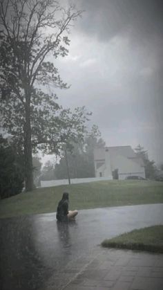 a person sitting in the rain with an umbrella