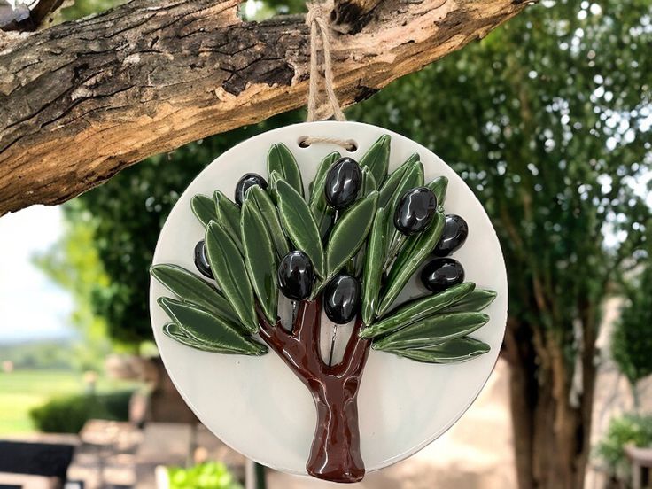 an olive tree ornament hanging from a tree branch