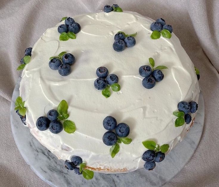 a cake with white frosting and blueberries on it