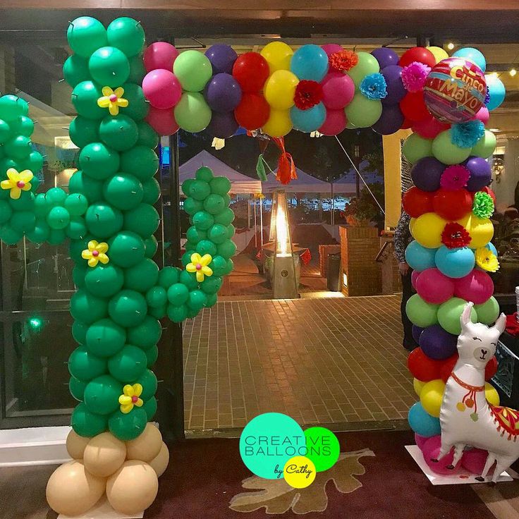 an arch made out of balloons with a horse and cactus on it in front of a building