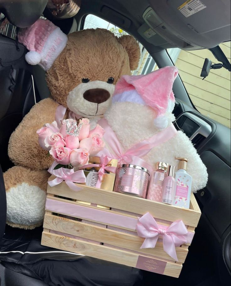 a teddy bear sitting in the back seat of a car next to a wooden crate