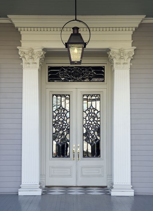 a white front door with two glass panels and a lantern hanging from the ceiling above it