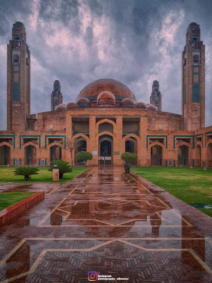 a large building with two towers on top of it's sides and a walkway leading to the entrance