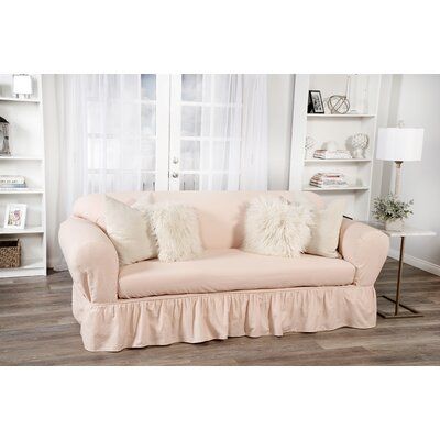 a living room with a pink couch and white bookshelves