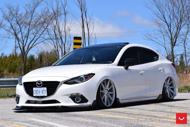 a white car is parked on the side of the road