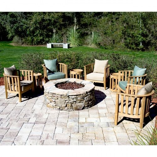 an outdoor fire pit surrounded by wooden chairs