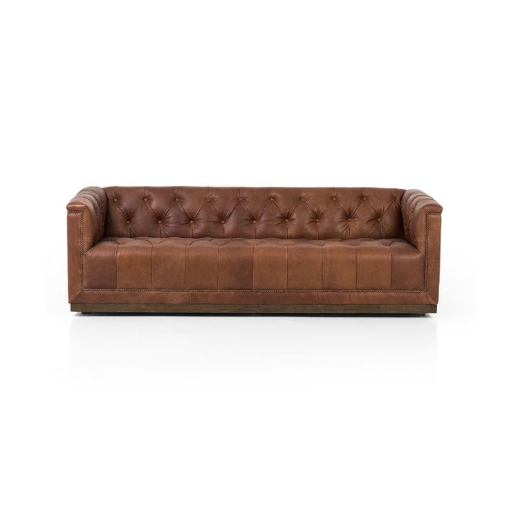 a brown leather couch sitting on top of a white floor