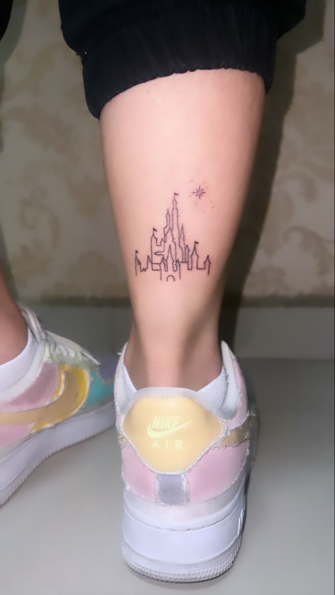 a woman's foot with a tattoo on her left leg and the word disney written in black ink