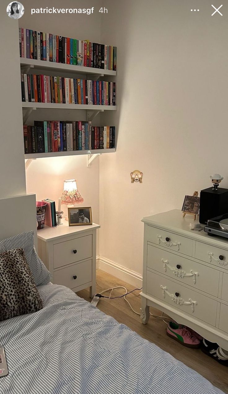 a bed room with a neatly made bed and a book shelf on the wall above it