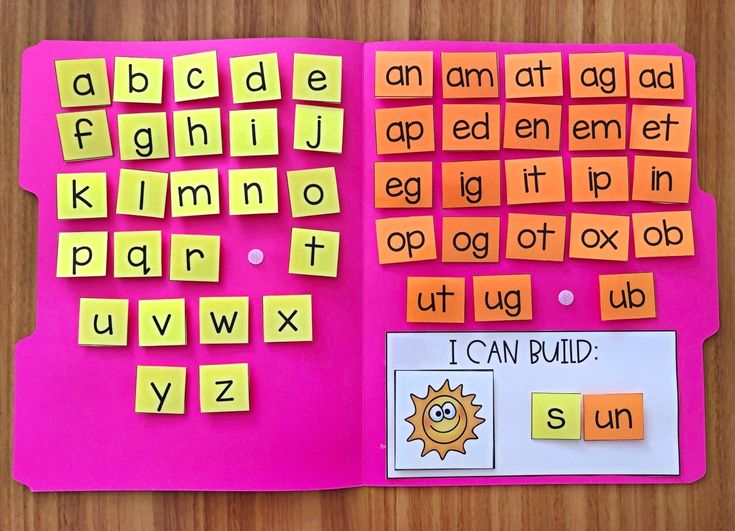 a pink book with orange and yellow letters on it, sitting on a wooden table