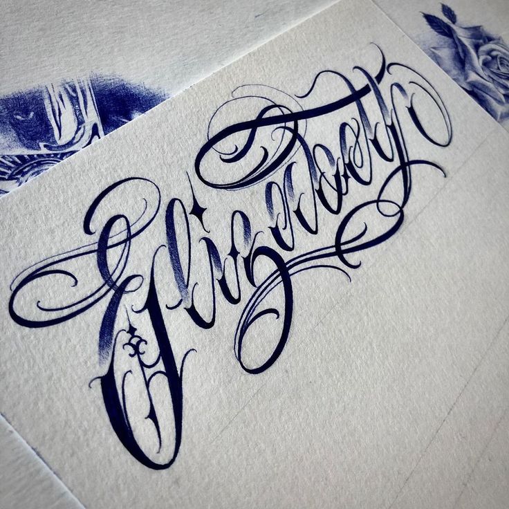 some type of calligraphy that is on top of a piece of paper with ink