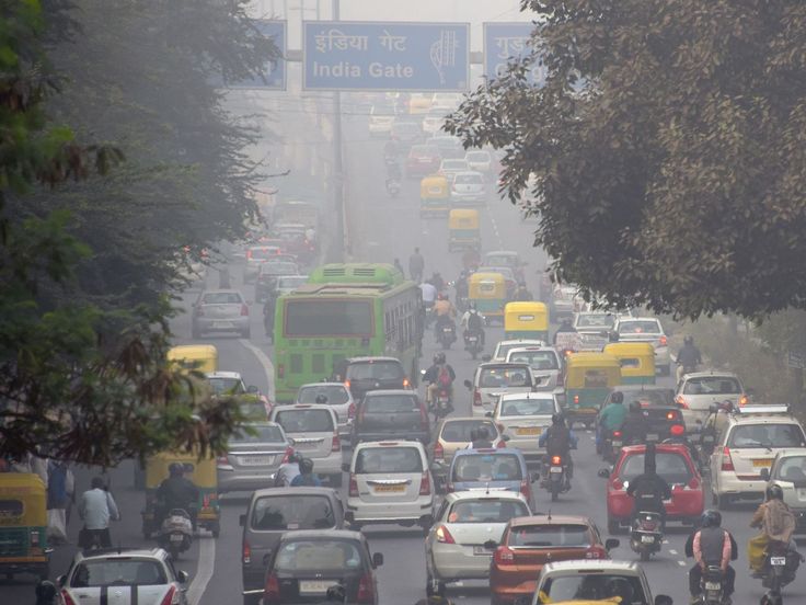 many cars and buses are driving down the street in heavy traffic on a foggy day