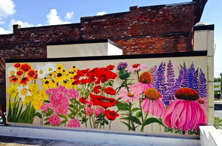 a mural on the side of a building with flowers painted on it's sides