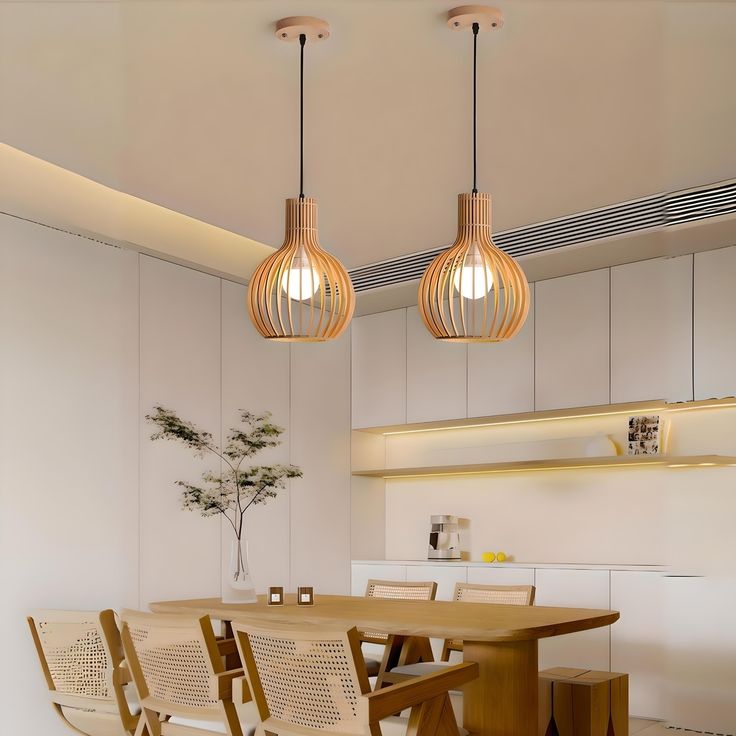 a dining room table and chairs with lights hanging from the ceiling