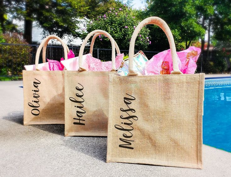 three jute bags with the words welcome home on them next to a swimming pool