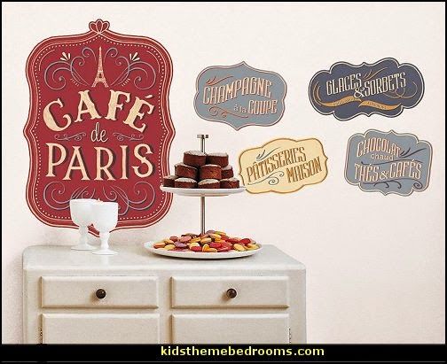 a table topped with cakes and desserts next to a wall mounted sign that says cafe de paris