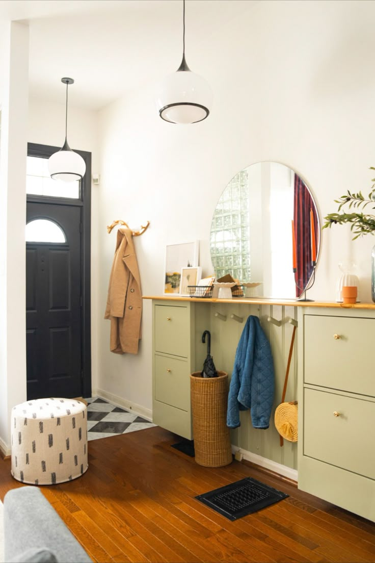 a room with a mirror, coat rack, and stool in the middle of it