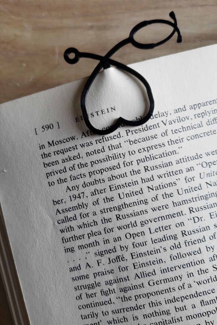 an open book with a black string attached to it's cover and the title page