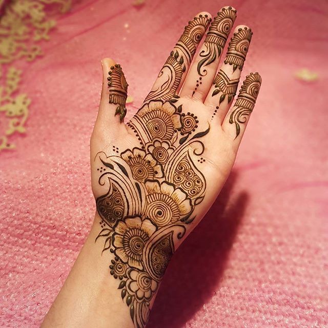 a woman's hand with henna tattoos on it