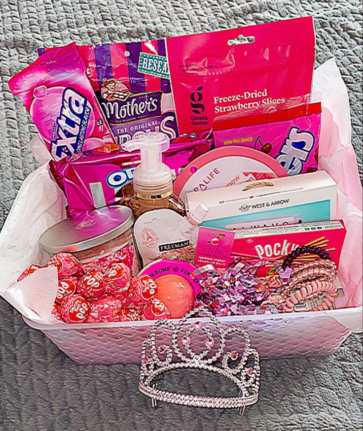 a white basket filled with lots of items on top of a bed next to a purse