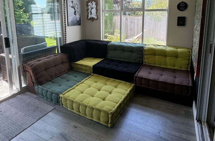 a multicolored couch sitting in front of a sliding glass door