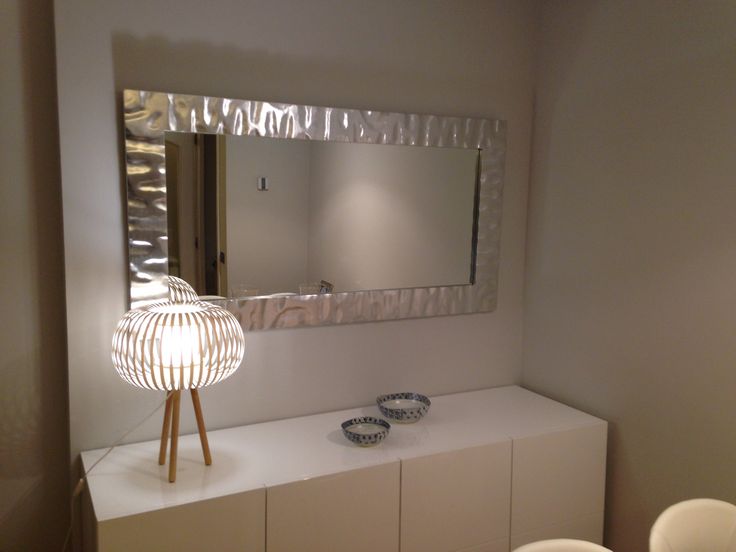 there is a mirror in the bathroom with two bowls on the counter next to it