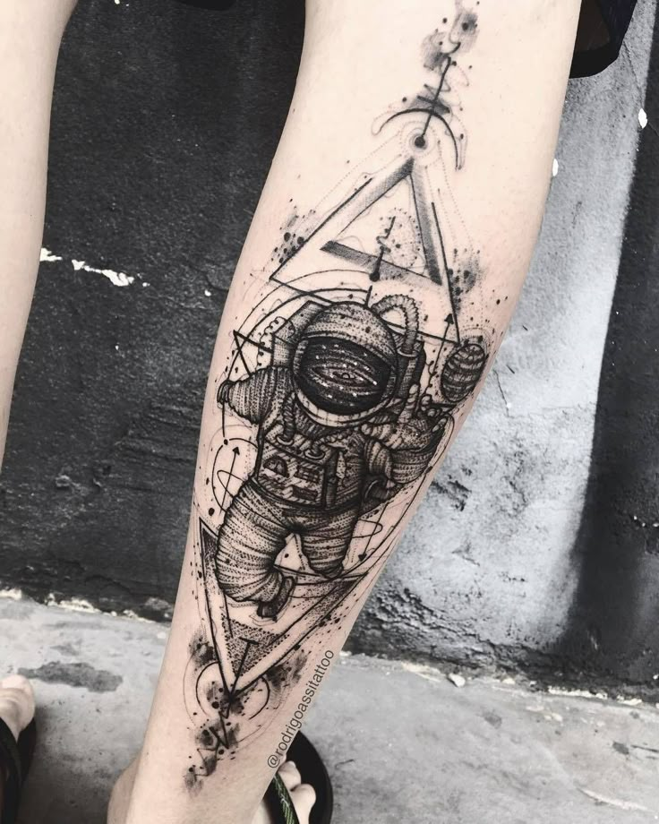 an astronaut tattoo on the leg