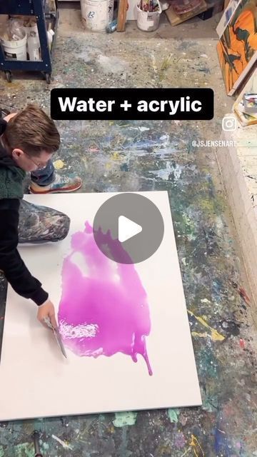 a young boy is painting on a canvas with water and acrylic inks