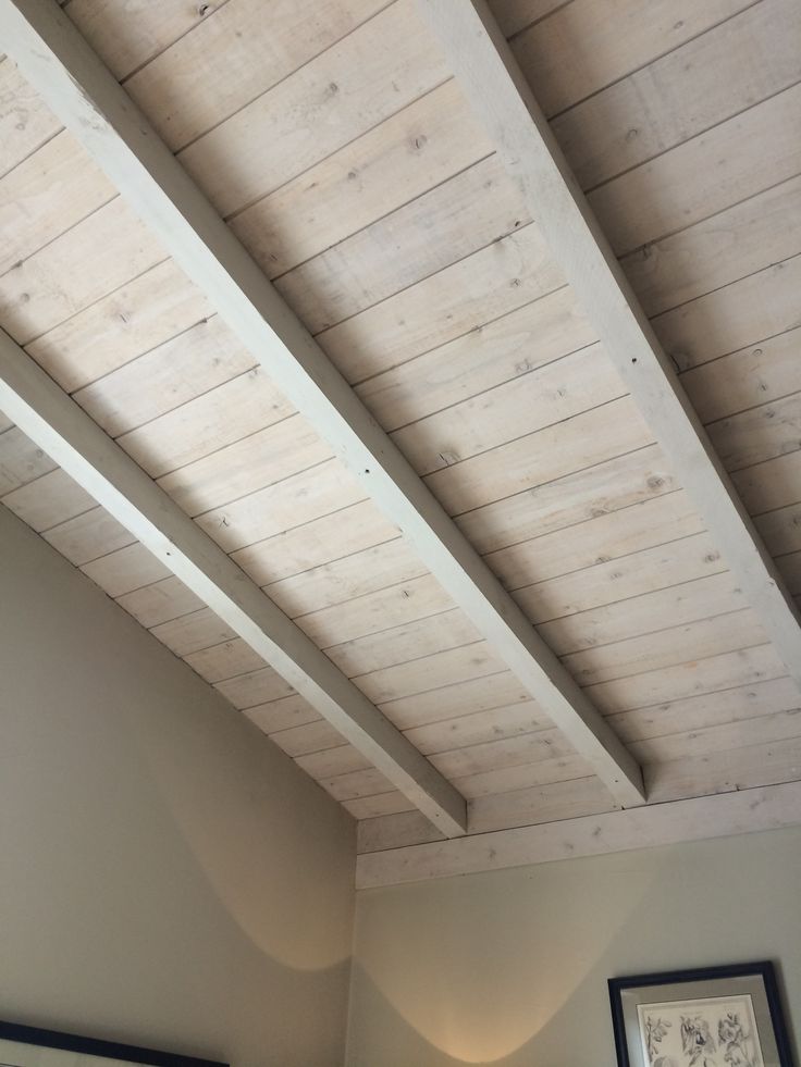 the ceiling is made of wood planks and has two lamps on each side of it