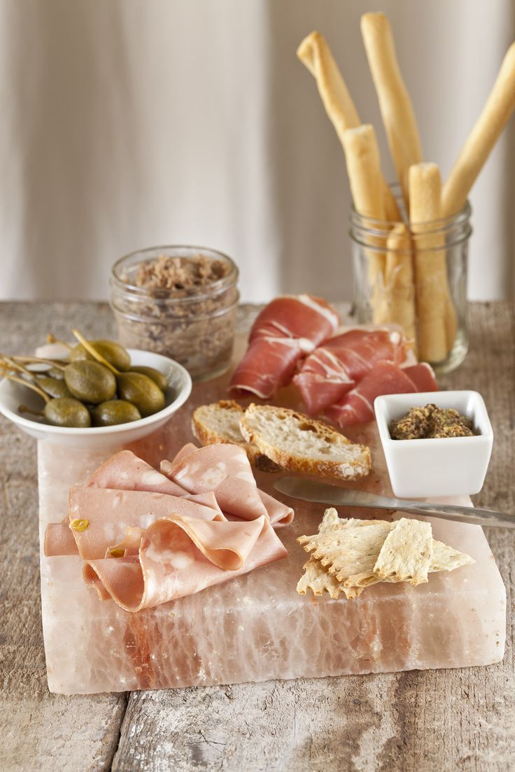 an assortment of meats and cheeses on a table