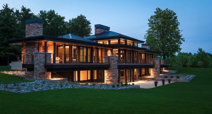 a large house that is lit up in the evening with lots of windows on it