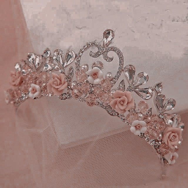 a tiara with pink roses and pearls on the headpiece is shown in this image