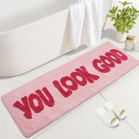 a bathroom rug that says you look good on the floor next to a bathtub