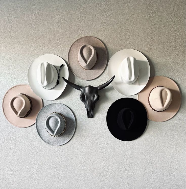 several hats mounted to the side of a wall with an animal's head on it