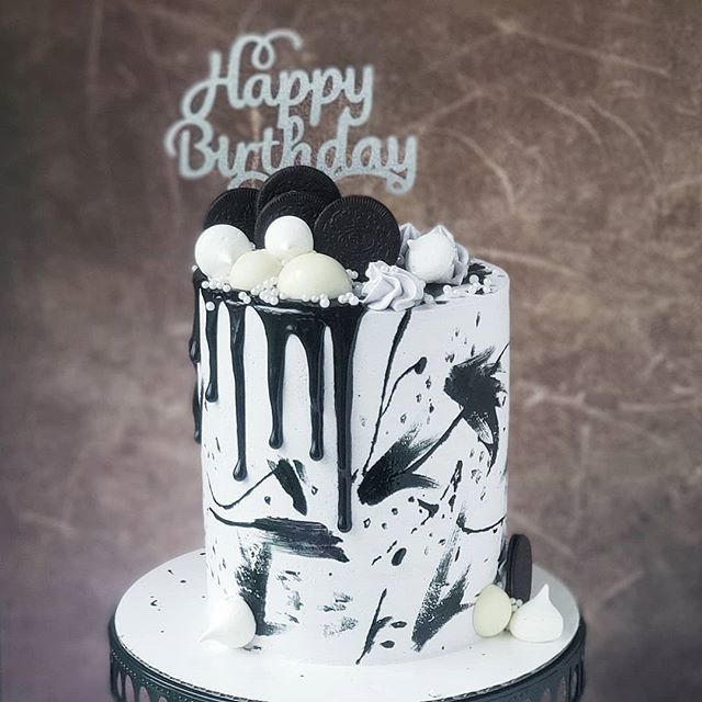 a birthday cake decorated with white and black icing